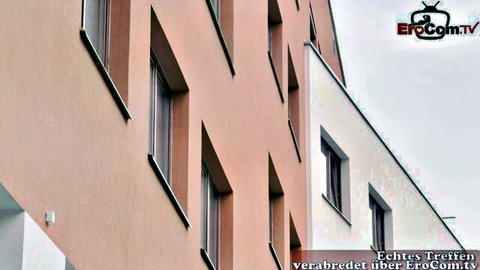Beige brick apartment building facade with windows featured on EroCom.tv amateur site