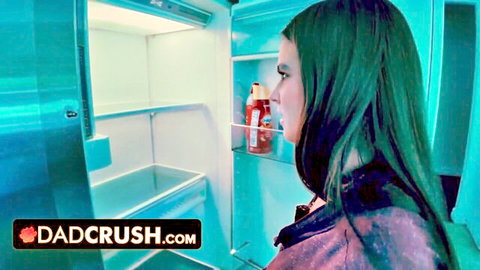 Long-haired brunette teen peeking into open fridge in tight top dadcrush kitchen tease