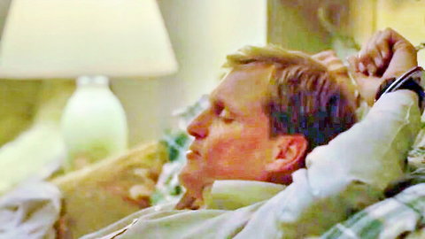 Handsome blond man lying relaxed on bed eyes closed white shirt open post-orgasm bliss