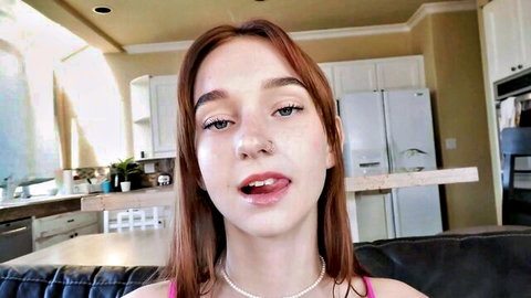 Cute redhead teen with small tits teases open mouth and tongue in pink top kitchen selfie