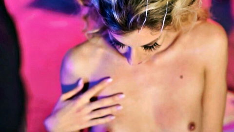 Blonde with heavy lashes squeezes her small bare tits topless closeup