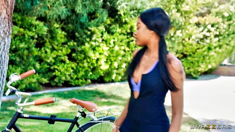 Sexy ebony babe in skimpy sling bikini flaunting huge cleavage by vintage bike outdoors
