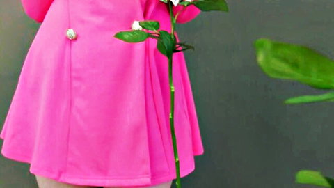 Daruma Rai in pink flared dress holding white rose, seductive solo pose