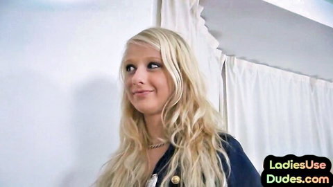 Blonde British femdom smiling in blue jacket for pegging trio