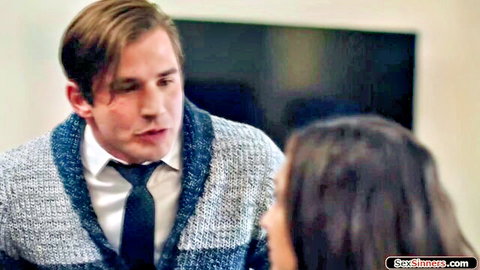 Couple in office attire, man in cardigan talking intensely to woman