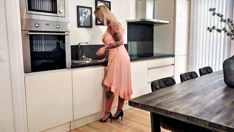 Blonde tattooed Ashley More bending in sexy pink dress