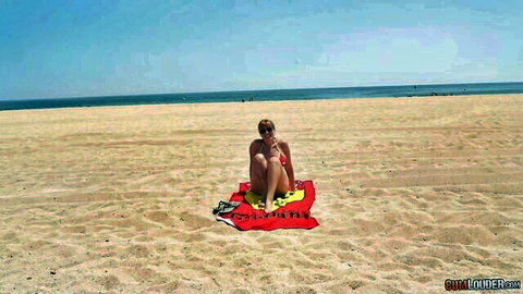 Busty blonde MILF in red bikini on sunny beach towel