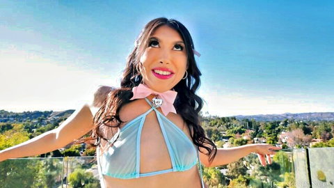 Penelope Woods in sheer blue lingerie, smiling outdoors with arms outstretched