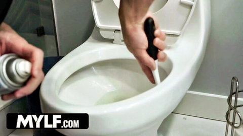 Hands spraying cleaner into toilet bowl while scrubbing vigorously with black brush