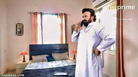 Indian man in white shalwar kameez on phone in bedroom, from chubby MILF erotic clip