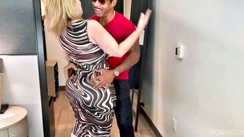 Danni Jones in tight wavy dress hugs smiling black stud King Cobra