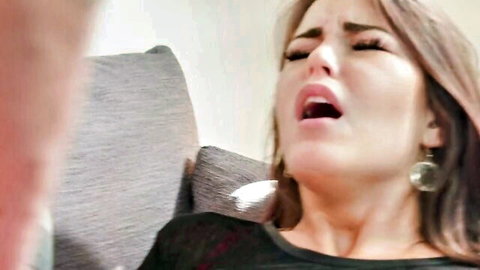 Hot babe moaning in ecstasy with wide open mouth and squinted eyes during intense couch sex