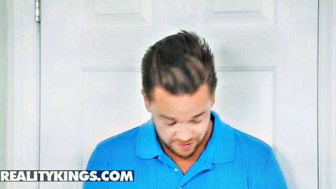 Handsome brunette stud in blue polo shirt smiling by door in Reality Kings porn video