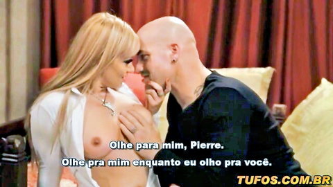 Blonde topless woman kissing bald tattooed man in Tomb Raider XXX parody