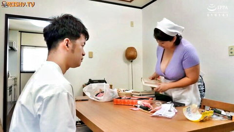 Busty Japanese nurse maid in low-cut top flashes deep cleavage serving food to young man in kitchen