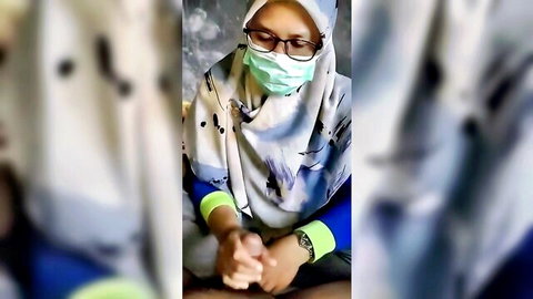 Blurry amateur Indonesian hijab girl in green mask and glasses sitting clothed