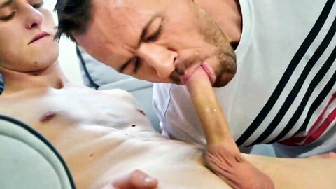 Bearded muscular DILF sucking slim twink's hard cock on couch