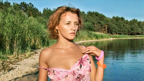 Busty redhead in pink floral dress flashing deep cleavage by sunny lake