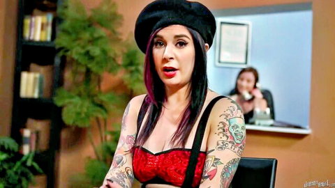 Tattooed brunette with pink hair in red lace bra showing deep cleavage surprised in office