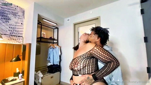 Ebony babe in sheer fishnet top with visible tits gropes boyfriend's cock during passionate neck kiss
