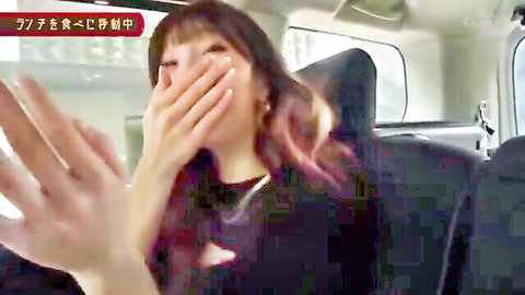Asian woman laughing covering mouth with hands in car backseat
