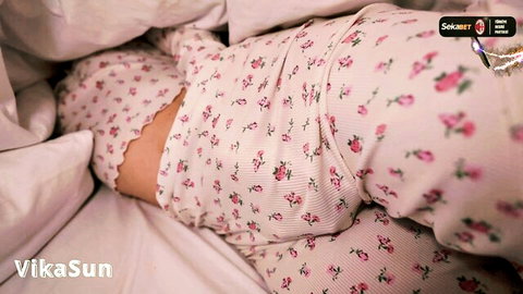 Hot brunette in pink floral lingerie lying seductively on bed