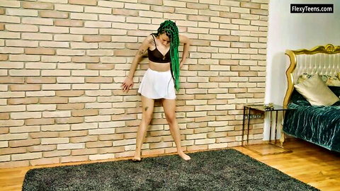 Flexible gymnast Didy Komod bending in black bra and white skirt