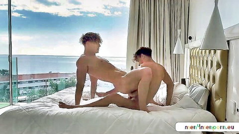 Blond twink bottomed doggystyle by hung top fucking his ass on luxury bed with ocean view