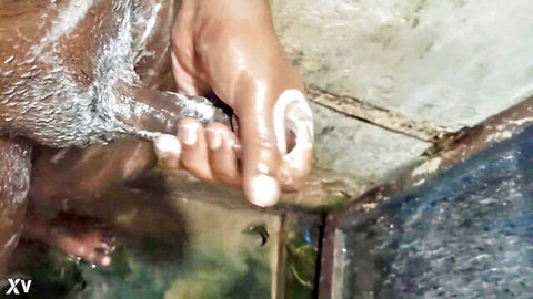 Indian man with big brown cock covered in soap suds gripped by wet hand in shower
