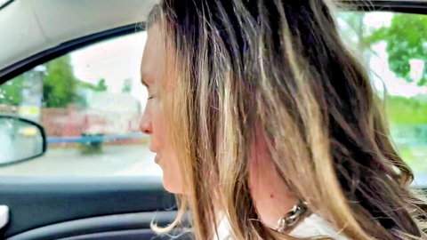 Blonde MILF in car with long wavy hair, side profile view