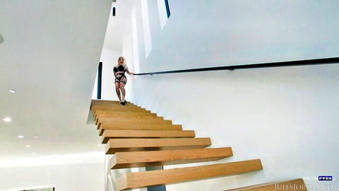 Kitana Montana in skimpy black dress ascending stairs, teasing with big tits
