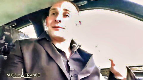 Suited man with headset talking and gesturing inside car interior