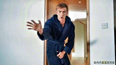 Shocked young ginger guy in bathrobe gesturing surprised at apartment door BraZZers