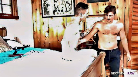 Two shirtless young brunette hunks embracing intimately in rustic bedroom before gay sex