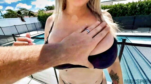 POV hand groping blonde's massive fake tits in black bikini by pool