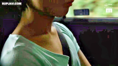 Sexy long-haired Japanese babe in tight green top showing cleavage in car