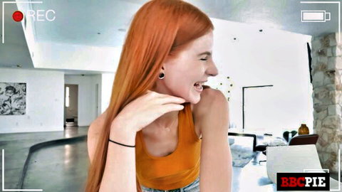 Smiling redhead babe in tight yellow tank top showing cleavage in BBCPIE studio