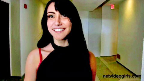 Young brunette amateur smiles in hotel hallway teasing red bra strap
