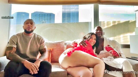 Curvy Latina BBW sits bottomless flashing shaved pussy and fat ass between two muscular black men on couch in interracial threesome tease