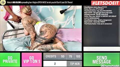 Tattooed blonde webcam girl spreads shaved pussy wide open on bed inviting tips