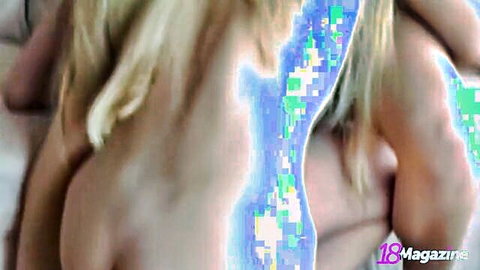 Two topless blonde lesbians embracing passionately with bare shoulders and long hair flowing.