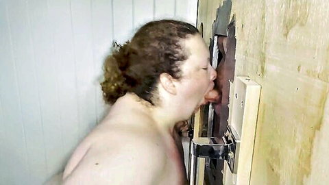 Curly redhead BBW sucking thick cock through glory hole wall