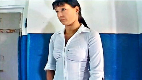 Mischel Channson as BDSM captive in tight white blouse, intense stare