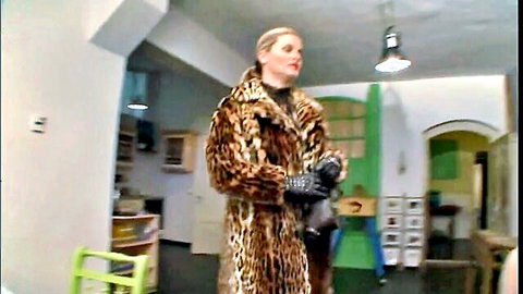 Blonde femdom dominatrix in leopard fur coat and black gloves