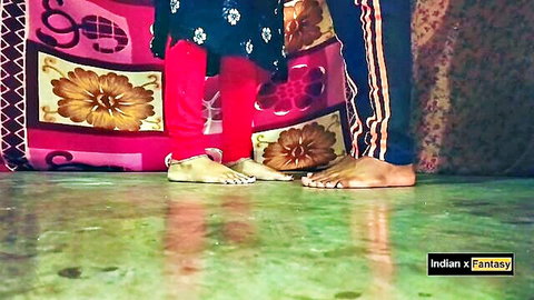 Indian woman's bare feet with red polish next to man's feet on bedroom floor tease