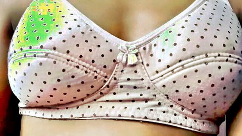Busty Indian woman's deep cleavage in colorful polka dot bra