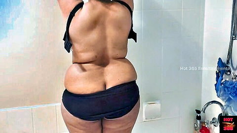 Curvy MILF strip teasing in bathroom, showing big ass