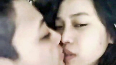 Intimate close-up kiss between Asian man and woman in kinky Chinese maid scene