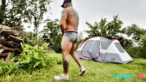 Muscular tattooed man in gray briefs at bi camping site, WhyNotBi studio