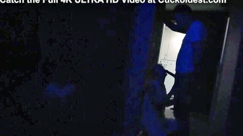 Shadowy cuckold scene with husband in blue shirt watching couple fuck in dark bedroom doorway